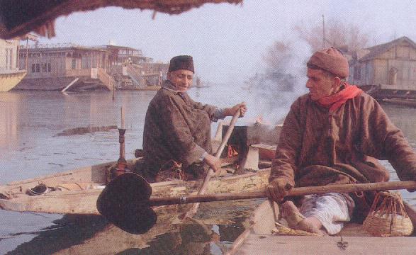 The boat people of Kashmir oar across Dal Lake on a winter morning.